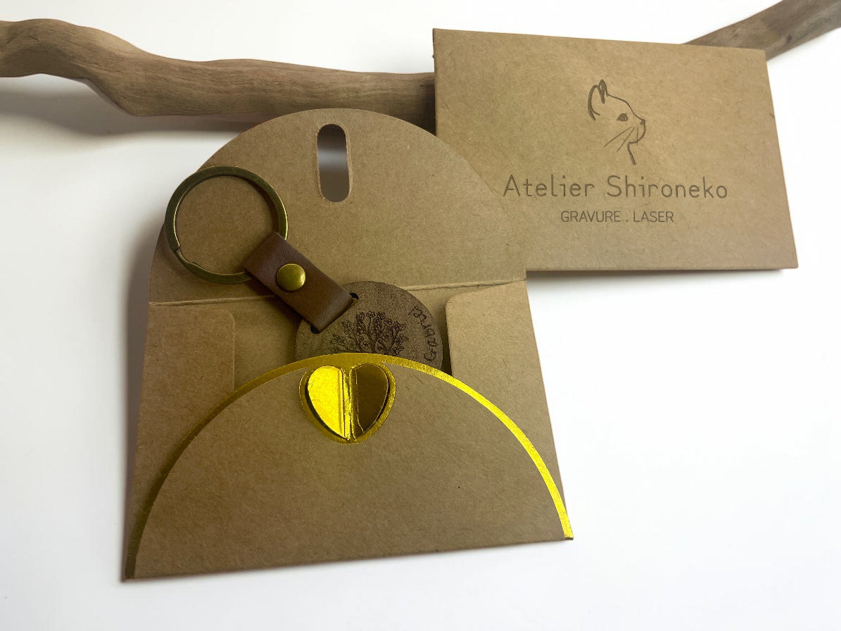 Porte-clés bois rond gravé prénom et feuillage, dans son emballage cadeau kraft Atelier Shironeko
