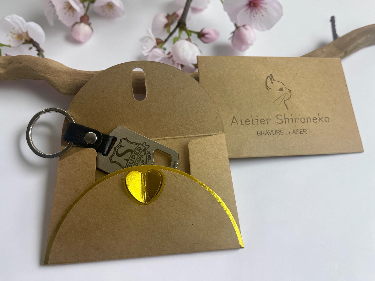 Porte-clés décapsuleur acier gravé Super Papa, dans sa pochette cadeau kraft Atelier Shironeko