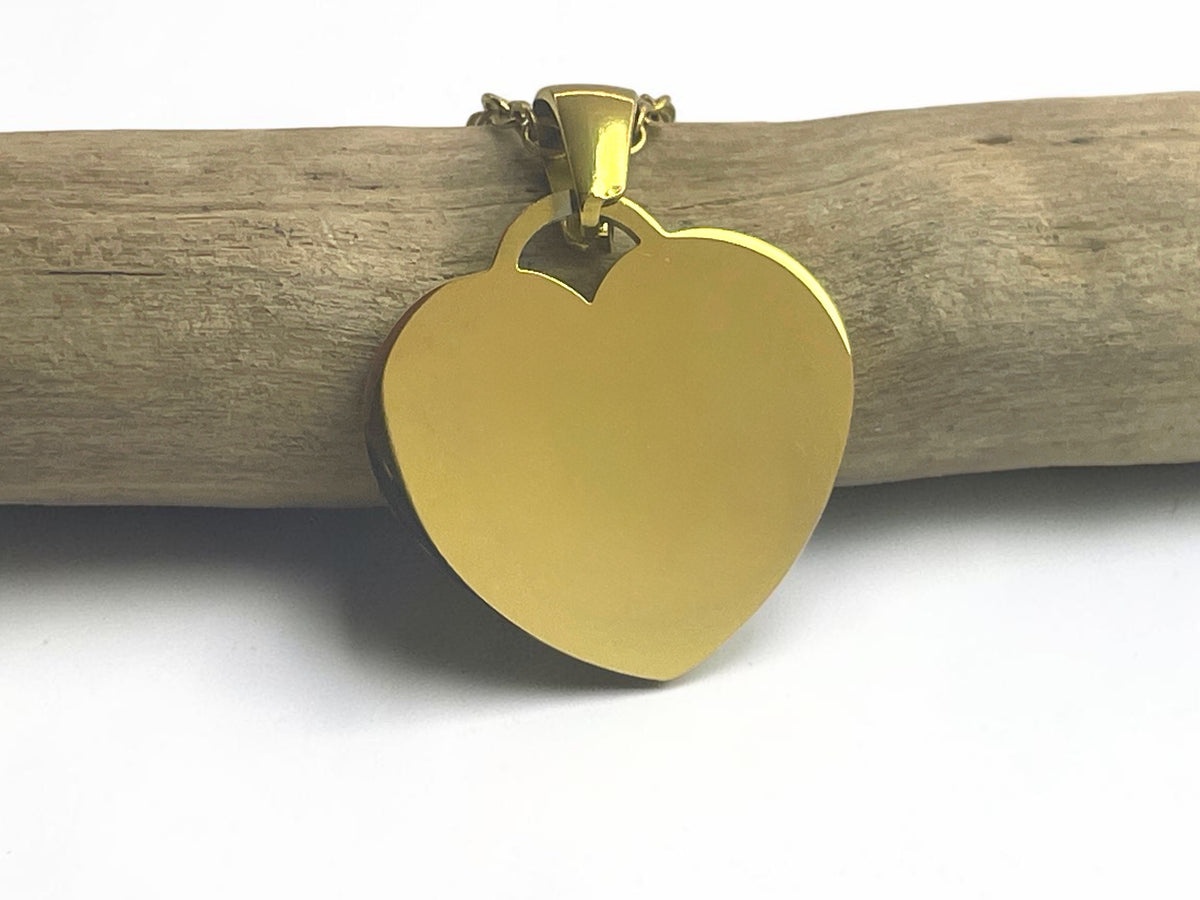 Collier cœur personnalisé en acier doré suspendu à une branche, face lisse prête à graver