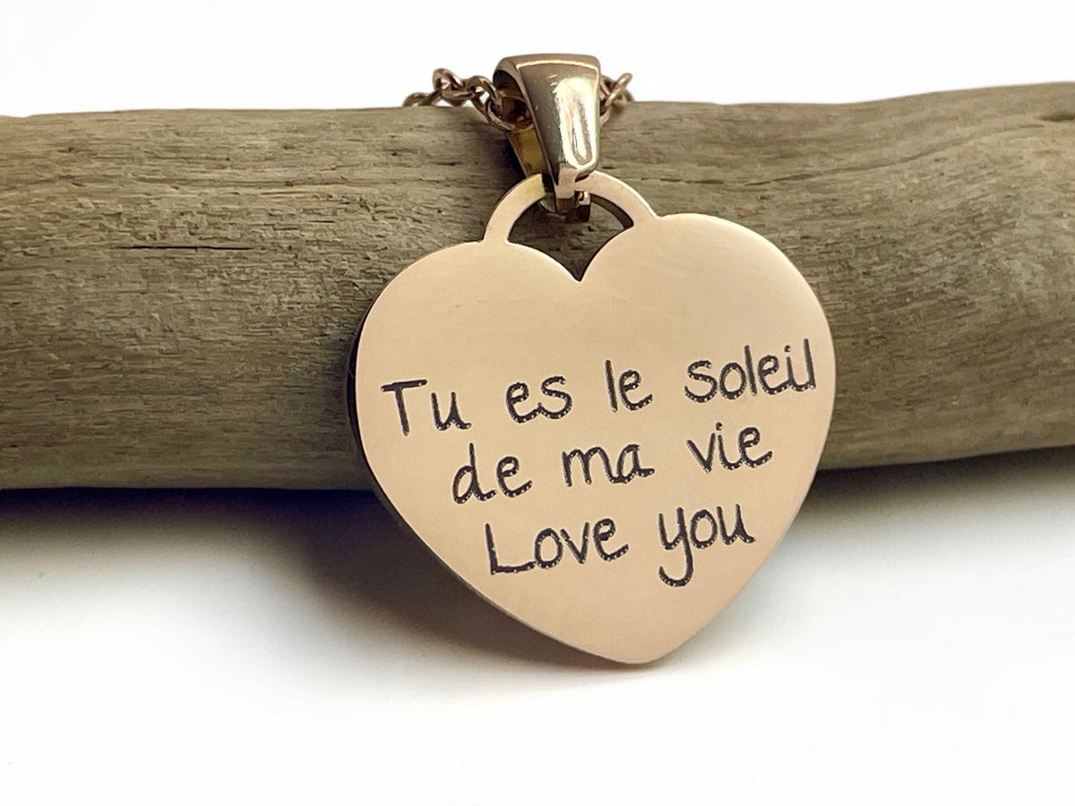 Verso d'un collier cœur or rose gravé d'un message manuscrit, Tu es le soleil de ma vie