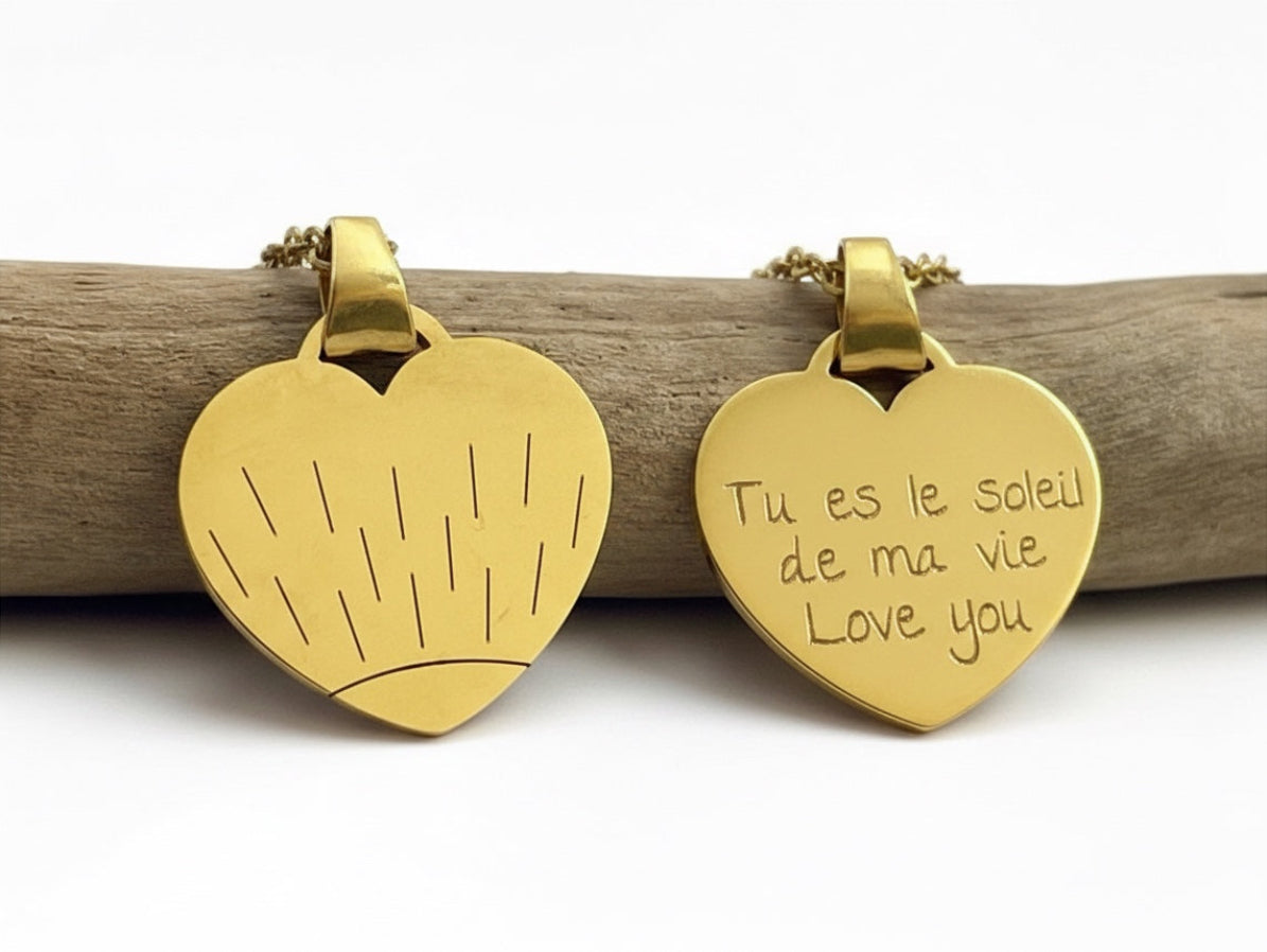 Recto et verso d'un collier cœur doré, motif soleil gravé et message manuscrit personnalisé