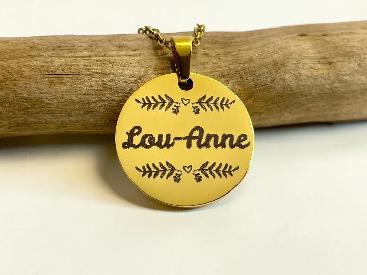 Collier médaille dorée gravée du prénom Lou-Anne entouré d'un feuillage