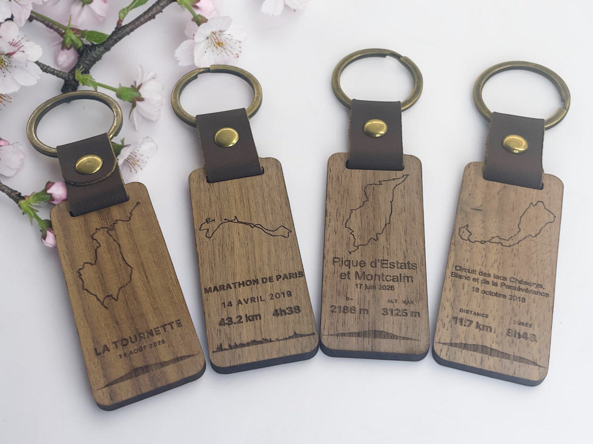 Quatre porte-clés bois GPX gravés de tracés de randonnée et de course, avec distance et dénivelé