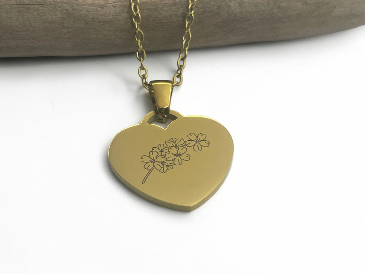 Collier cœur doré gravé d'une fleur sur chaîne dorée, vue de face