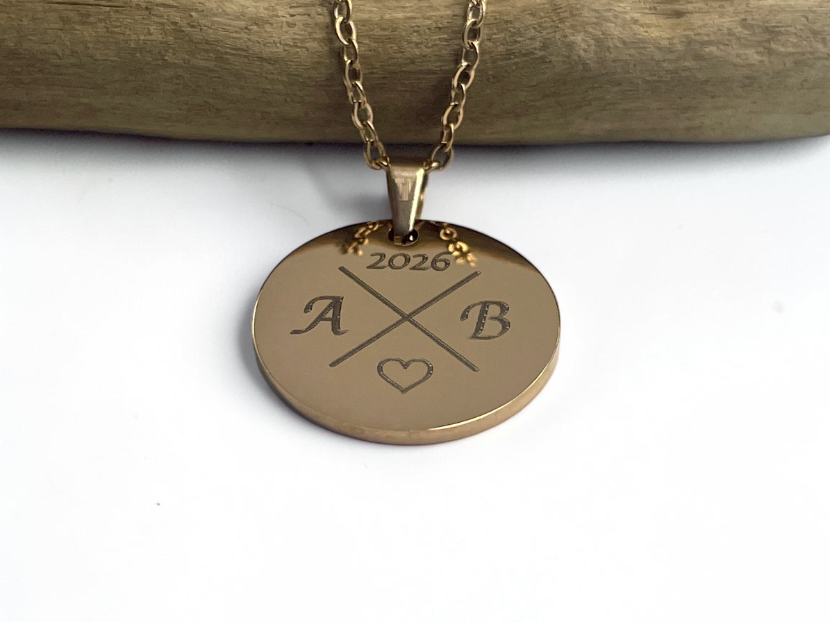 Collier médaille ronde doré gravé initiales et année, présenté sur sa chaîne fine