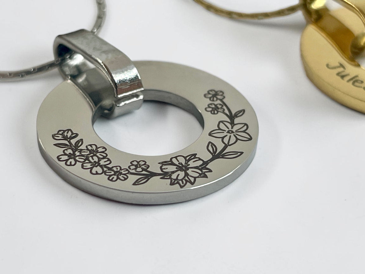 Gros plan de la gravure d'une couronne de fleurs sur médaille ajourée argentée