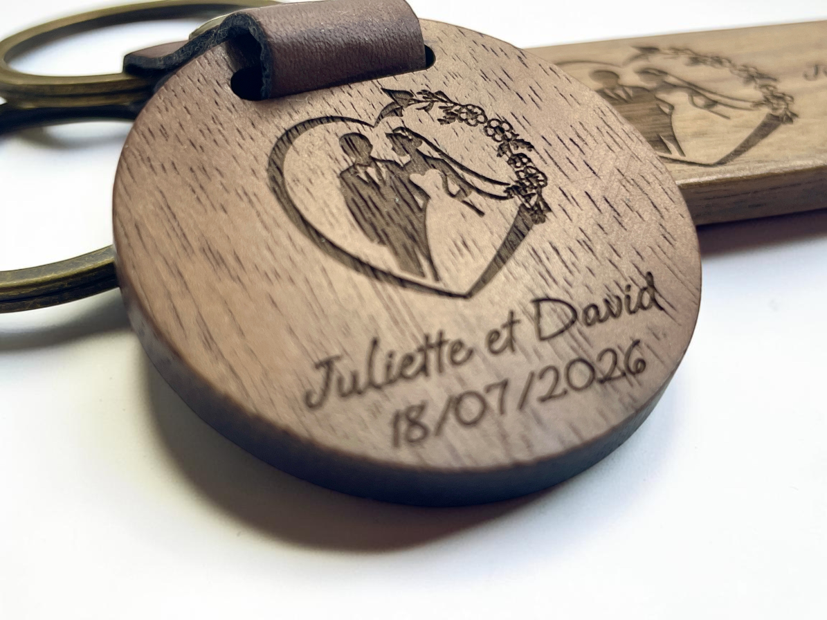 Gros plan de la gravure sur bois, couple de mariés, prénoms Juliette et David et date 18/07/2026