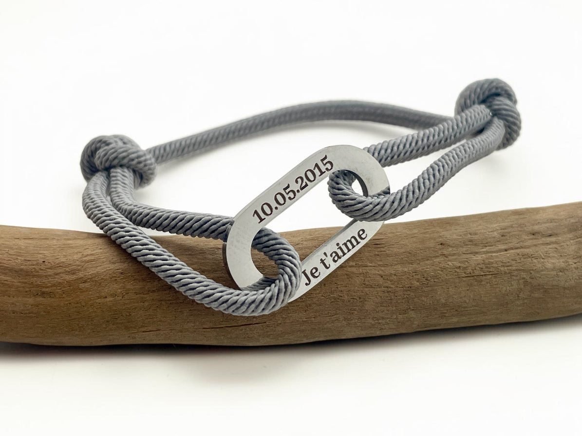 Bracelet cordon gris gravé de prénoms sur maillon acier, avec nœuds coulissants ajustables