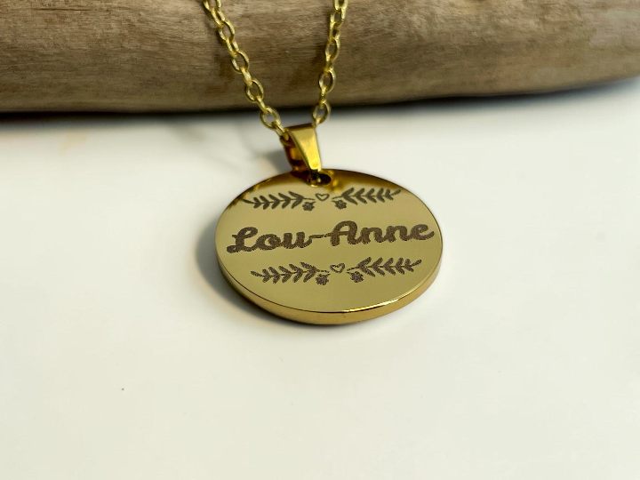 Collier médaille dorée gravée du prénom Lou-Anne, présenté sur sa chaîne fine