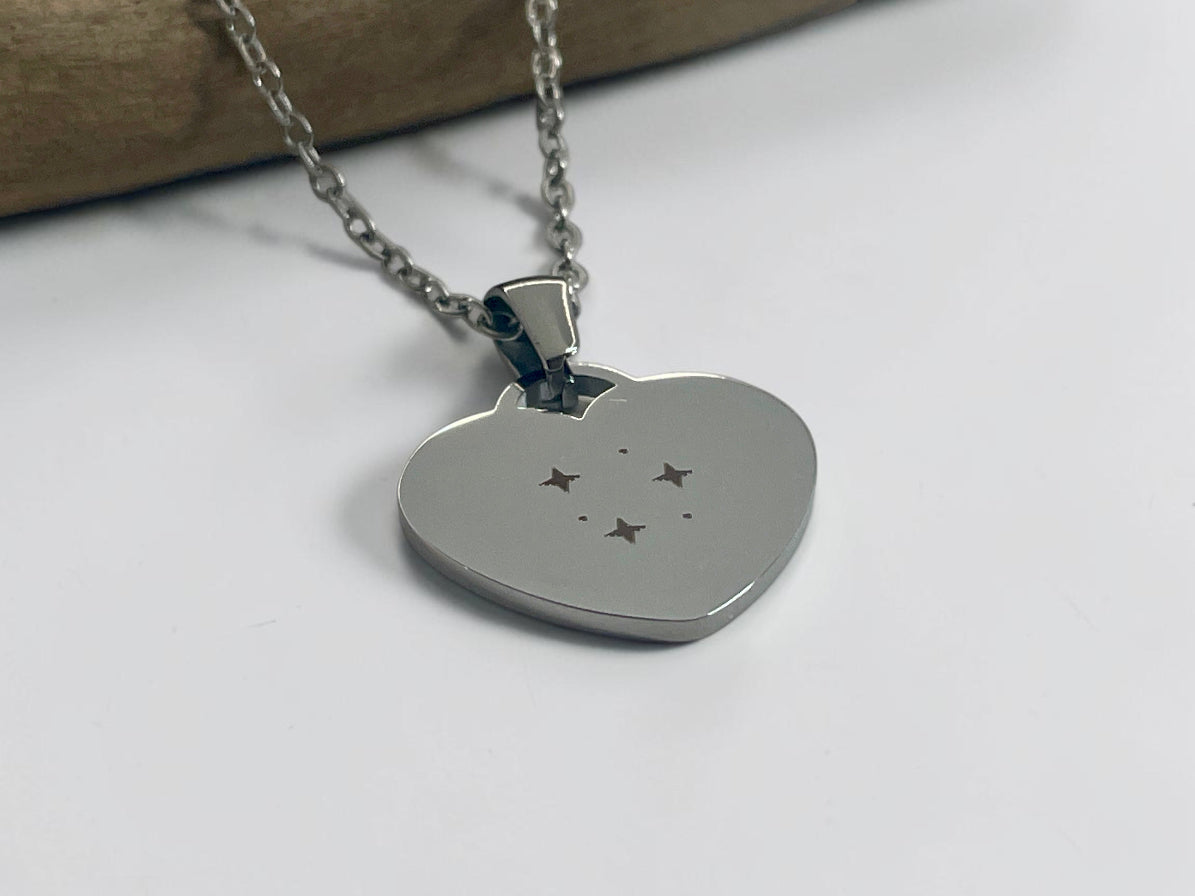 Collier cœur argenté gravé d'étoiles, présenté sur sa chaîne fine