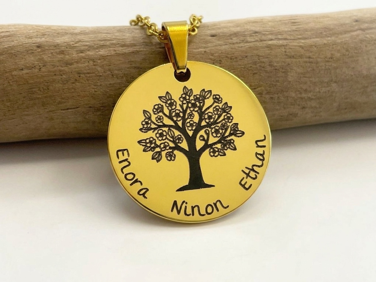 Collier arbre de vie doré gravé des prénoms des enfants, posé sur une branche de bois