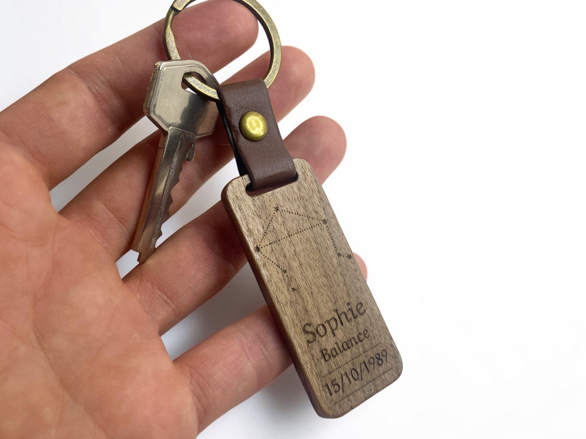 Porte-clés bois personnalisé tenu en main avec des clés, pour montrer sa taille réelle