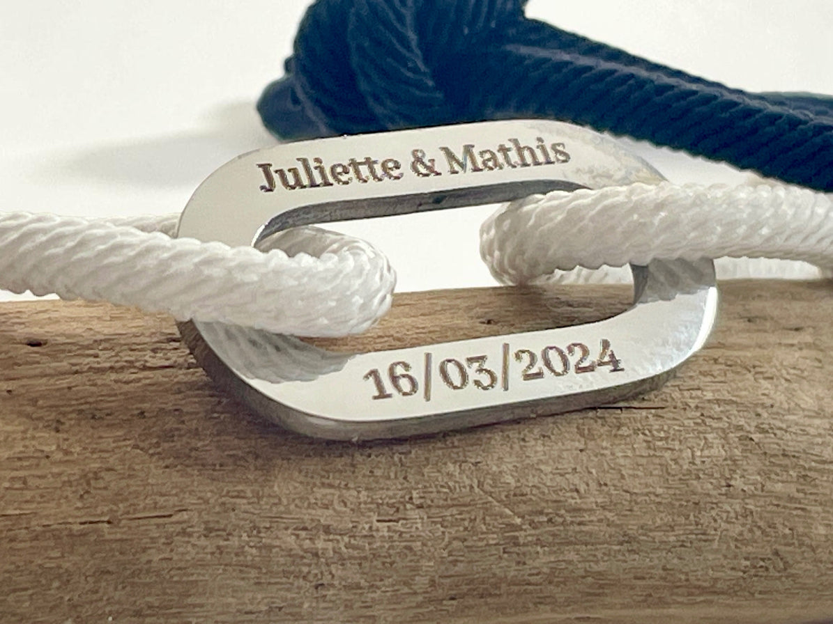 Gros plan de la gravure Juliette et Mathis avec la date 16/03/2024 sur maillons acie