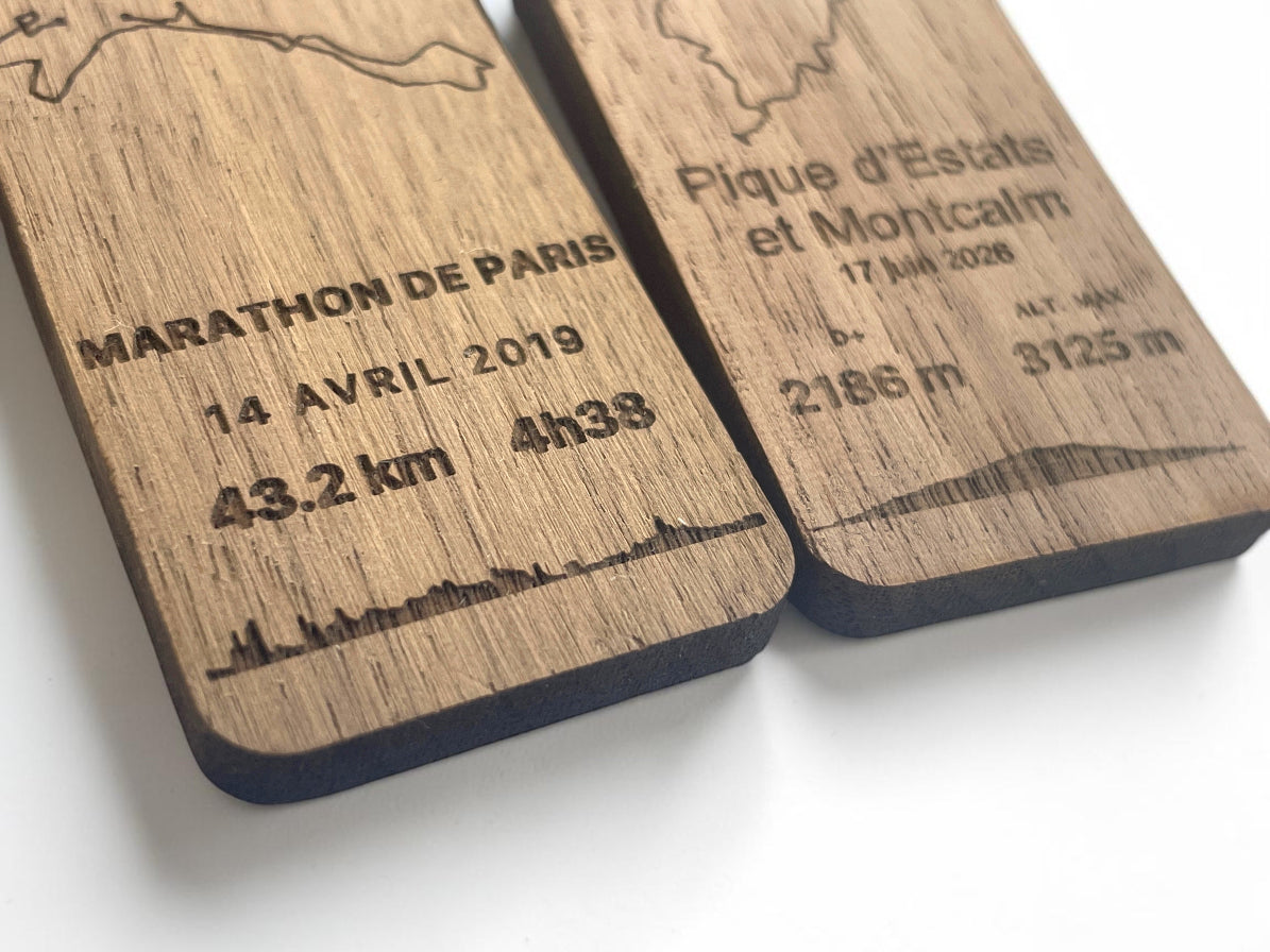 Gros plan de deux porte-clés bois GPX, marathon de Paris et Pique d'Estats et Montcalm