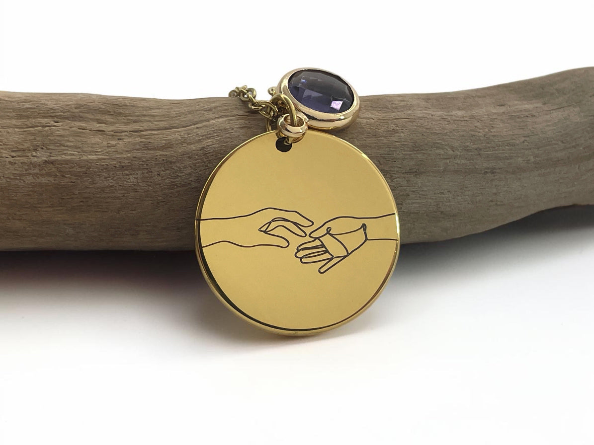 Collier médaille dorée gravée de deux mains qui se tiennent, avec pierre de naissance bleue