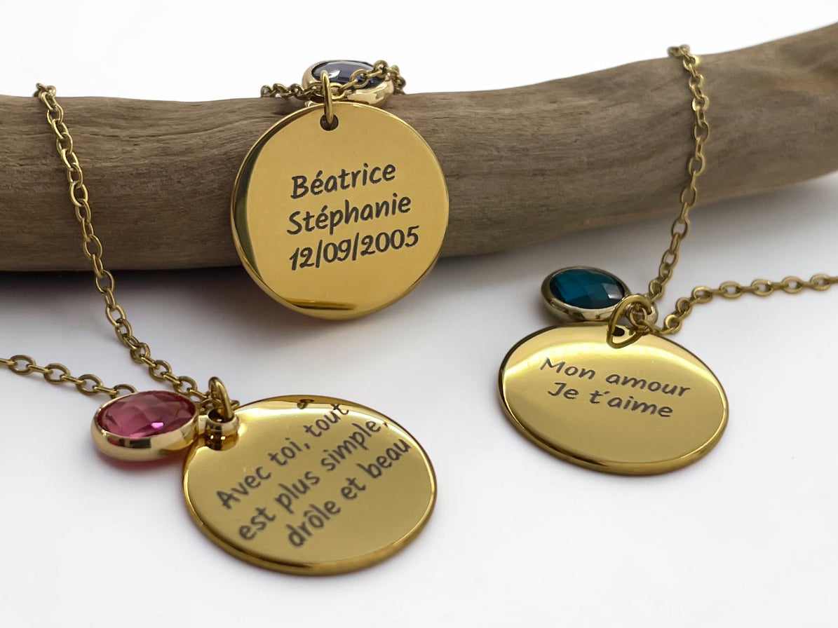 Deux colliers médaille dorée gravés de prénoms et d'un message, avec pierres de naissance