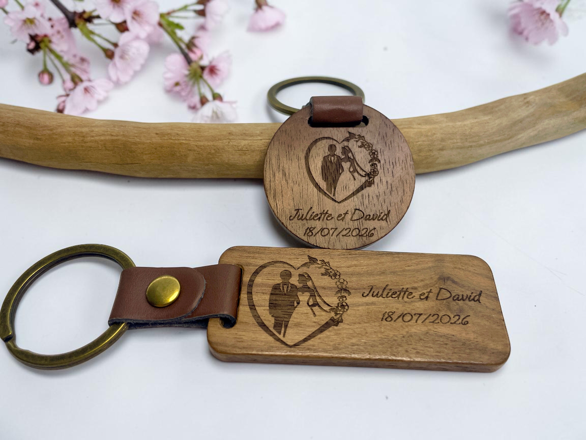 Porte-clés bois personnalisés mariage posés sur une branche fleurie de cerisier