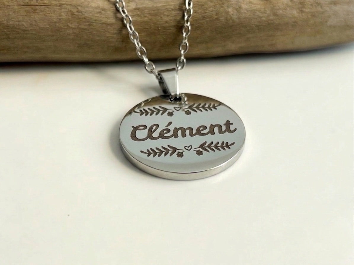 Collier médaille argentée gravée du prénom Clément, présenté sur sa chaîne
