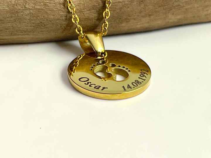 Collier naissance doré gravé prénom et date, présenté sur sa chaîne fine