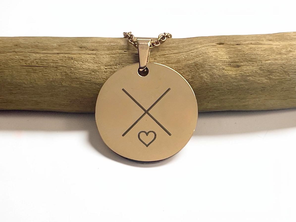 Collier médaille ronde en acier doré gravé d'une croix et d'un cœur, suspendu à une branche