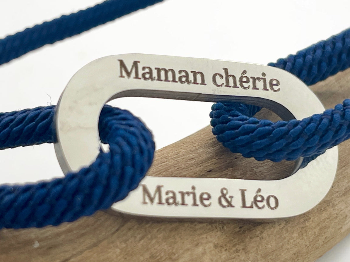 Gros plan de la gravure Maman chérie et des prénoms Marie et Léo sur maillon acier