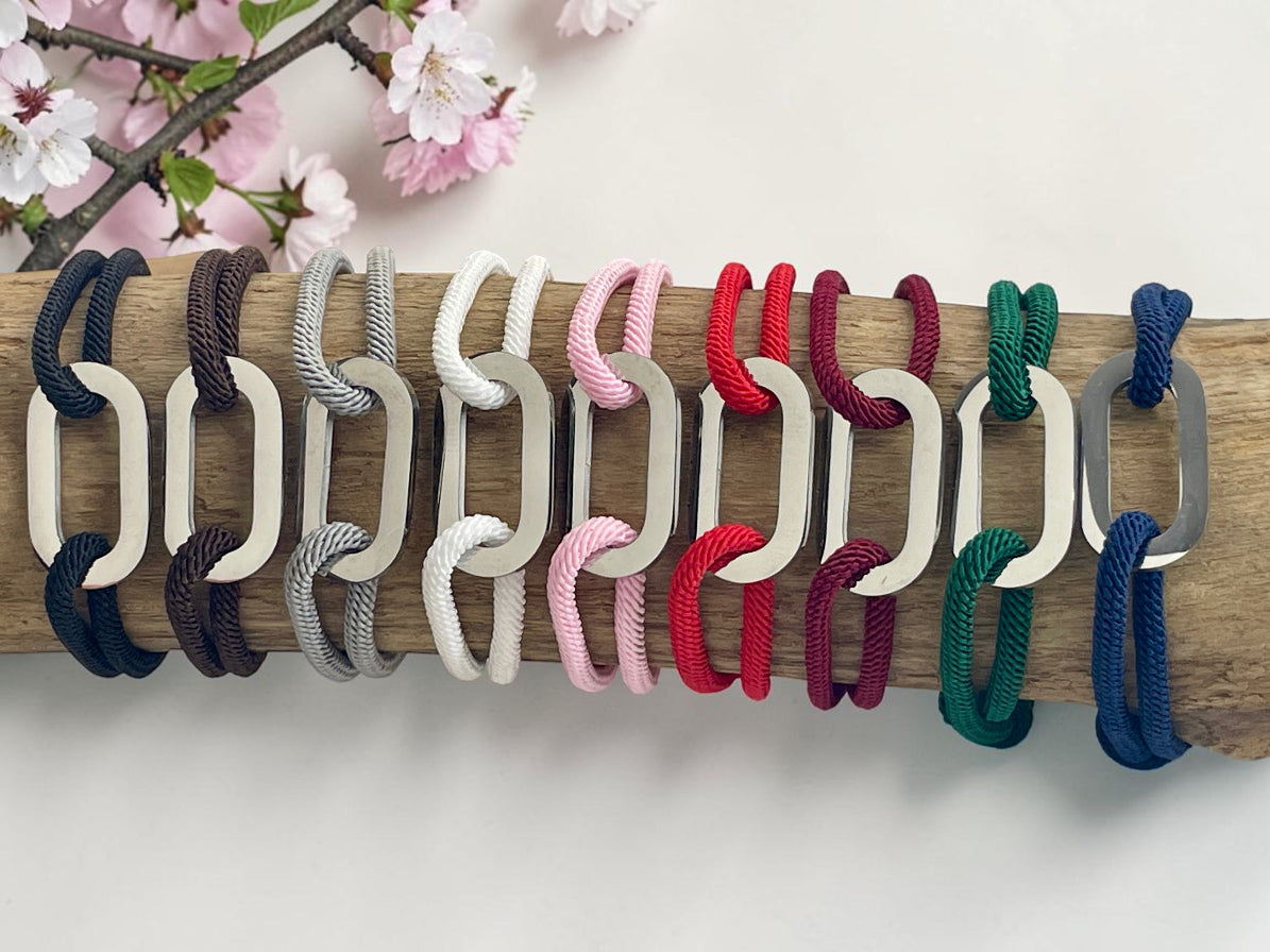 Nuancier des coloris de bracelets cordon disponibles, maillons acier alignés sur une branche